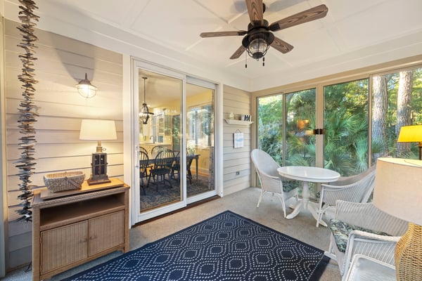 Waterfront deck with swimming pool, hot tub, and river view surrounded by mature trees and palm trees